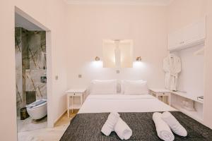 雅典Neapolis 1897 Boutique Luxury Rooms的白色卧室配有床和2条白色毛巾