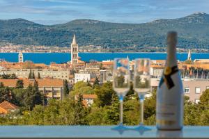 扎达尔Stella Maris 2BDR, balcony, sea view, garage, BBQ的两杯酒杯旁的一瓶葡萄酒