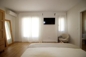 洛萨尔德拉韦拉Casa Verata的一间卧室配有一张床、一把椅子和电视