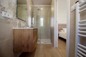 洛萨尔德拉韦拉Casa Verata的一间带水槽和淋浴的浴室以及一张床