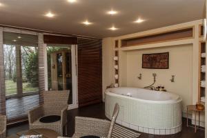 佩奇Hilltop Wellness Villa-big garden, sauna, hot tube的带浴缸和桌椅的浴室