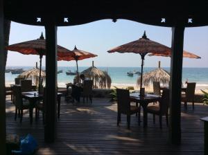 额布里佑玛樱桃旅舍的海滩上的餐厅,配有桌子和遮阳伞