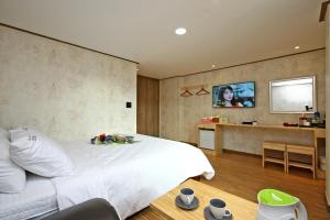 加平特劳姆酒店公寓的卧室配有白色的床和平面电视。