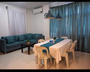 BisligGLC SUITES的客厅配有桌子和蓝色沙发