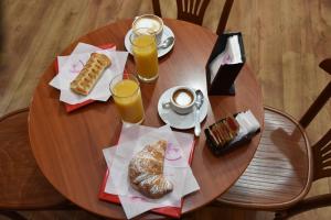努奥罗B&B LE DUE ISOLE的一张带食物和两杯橙汁的木桌