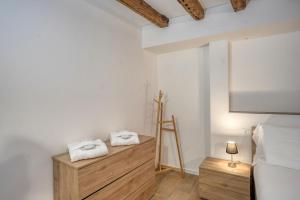 威尼斯Ecco Suites Apartments的一间白色墙壁、投影屏幕和毛巾的房间