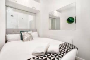 奥克兰THE VIADUCT WATERFRONT LUXURY - Views & Location!的白色卧室配有一张带镜子的床