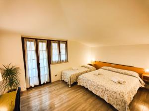 马内尔巴Albergo B&B Tenesi的酒店客房带两张床和两个窗户