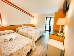 马内尔巴Albergo B&B Tenesi的酒店客房设有两张床和电视。