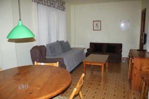 索特阿德莱达佩赛特斯公寓的客厅配有桌子和沙发
