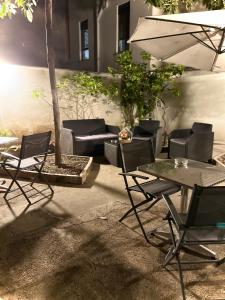 巴勒莫LE PORTE DI PALERMO的庭院配有桌椅和遮阳伞。