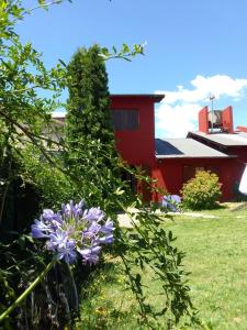 坦迪尔Casa Bordó, B & B的一座鲜花盛开的花园,一座红色的建筑