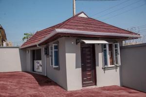 伊巴丹TFP Lodge的一间白色的小房子,有红色的屋顶