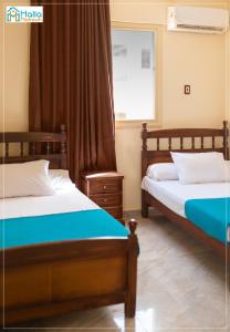 马特鲁港Halla Matrouh的一间卧室设有两张床和窗户。