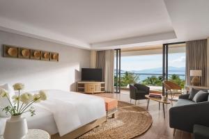 芽庄Boma Resort Nha Trang的一间带白色大床的卧室和一间客厅