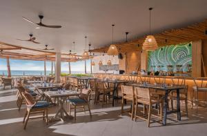 芽庄Boma Resort Nha Trang的一间设有桌椅的海洋餐厅
