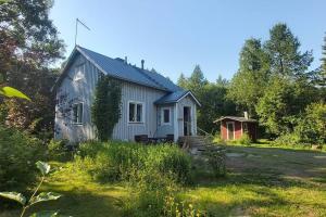 KontiolahtiVilla Mäntysaari luonnonrauhaa kaupungin lähellä.的院子中间的白色小房子