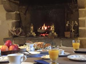 Dragey勒多米尼贝尔维尔酒店的餐桌、食品和饮料以及壁炉