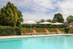 圣耐克森La Chartreuse du Bignac - Teritoria的一组椅子和遮阳伞,位于游泳池旁