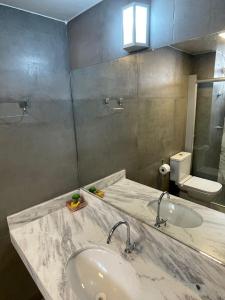 戈亚尼亚Apartamento aconchegante 1911的一间带水槽和镜子的浴室