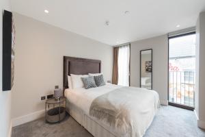 伦敦New Build-Air Con-2 Bedroom-Two Bathrooms Apt 3的白色的卧室设有一张大床和一个窗户