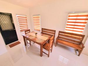 公主港Palawan two bedroom home in puerto princesa city的一间带木桌和2个长凳的用餐室