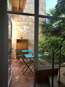波尔多Maison d'hôtes Alma的一个带桌椅的庭院和一个窗户。