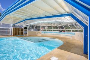 AllardsMobil Home XXL 4 chambres - Camping Ostrea的一座室内游泳池,拥有一座大型玻璃建筑