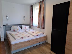 上蒂利拉赫Appartement Haus Gatterer的一间卧室配有带两个枕头的床和窗户