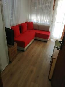 索科矿泉村Apartmani ,studija i sobe Savić的客厅配有红色沙发和电视