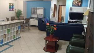 恩卡纳西翁亚瑟香巴拉酒店的客厅配有蓝色的沙发和带鲜花的桌子