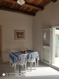 多纳卢卡他Casa vacanze La Meridiana的餐桌、椅子和蓝白桌布