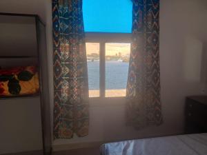阿斯旺Kafana Guest House Nile View的一间卧室设有水景窗户