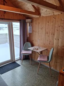SandavágurHjallurin的一间设有两把椅子、一张桌子和一个窗户的房间