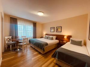 巴利纳斯洛Moycarn Lodge & Marina的酒店客房带两张床和一张桌子以及椅子。