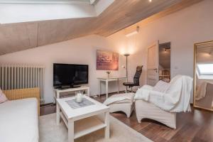 科尔贝尔莫尔Modernes Apartment zum Wohlfühlen的客厅配有白色家具和平面电视