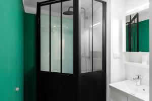 卡尔卡松艾乐欧公寓酒店的浴室设有黑色的门和绿色的墙壁