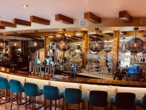 巴利纳斯洛Moycarn Lodge & Marina的一间酒吧,房间内设有蓝色椅子