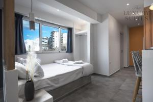 塞萨洛尼基Horizon Apartments, The Luxury Suites的一间卧室设有一张床和一个大窗户