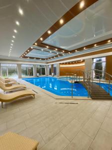 Velikaya DobronʼSting Hotel & Event Palace的一座带楼梯的大楼内的大型游泳池