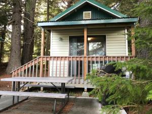 海恩斯Cabin 3 Lynn View Lodge的树林中的小房子,带长凳