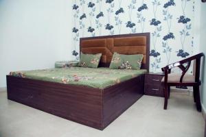 马图拉2 BHK Independent Flat at Ganpati Infinity Vrinadvan的一张木床,椅子放在一个房间里