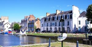 雷恩Hostel Rennes HI的一座有建筑的城市和一条有船的河流