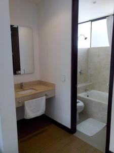 梅尔加Suite Sumapaz Hotel的一间带水槽、浴缸和卫生间的浴室