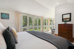 基督城Fendalton Villa - Christchurch Holiday Home的一间卧室配有一张床、梳妆台和窗户。