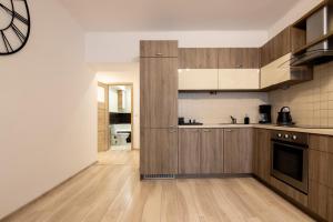 克拉科夫THE SOUL of Nowa Huta - free garage的一间铺有硬木地板的大厨房,配有木制橱柜
