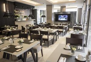 瓦伦西亚维奇美尔卡特酒店的餐厅设有桌椅和平面电视。