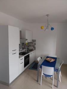 奥特朗托Appartamento Memorie的厨房配有白色橱柜和蓝色桌子