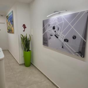萨莱诺B&B Salerno Urban Suite 57的墙上一幅画,在屋子里用植物