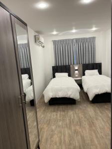 Al QasţalCaprios motel的一间卧室配有两张床和镜子